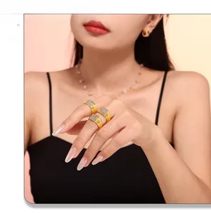 Model wearing stacked gold rings with square pavé diamonds and matching earrings