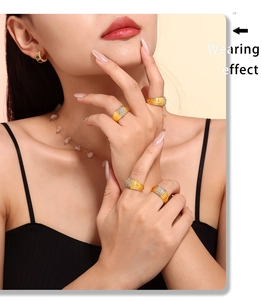 Detailed view of wide gold textured rings with rhinestones worn with matching jewelry