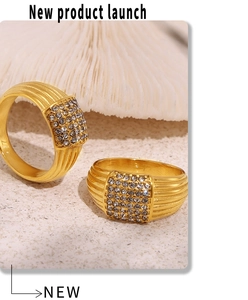 Macro shot of gold-layered rings with square pave-set diamonds on white coral