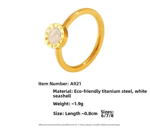 Détail d'une bague en acier doré avec nacre blanche et gravures de signes du zodiaque