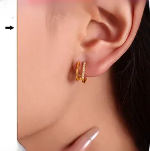 Gros plan sur des boucles d'oreilles doubles en C dorées ornées de strass brillants