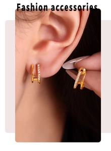 Gros plan sur des boucles d'oreilles C dorées doubles avec pavé de zircons