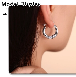 Gros plan de boucles d'oreilles créoles argentées avec cinq perles blanches sur un mannequin