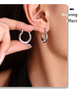 Effet porté de boucles d'oreilles créoles argentées avec perles sur un mannequin réel