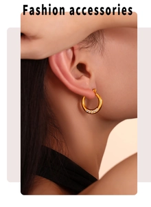 Gros plan de créoles dorées avec perles blanches portées par un mannequin de style luxe