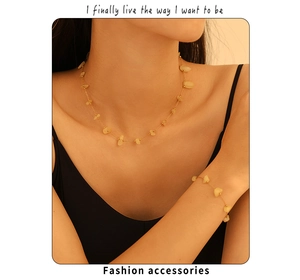 Détail d'un ensemble collier en pierres naturelles et bracelet doré porté par un mannequin