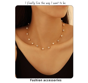 Elegantly styled necklace featuring white pearls and marble beads on a gold chain
