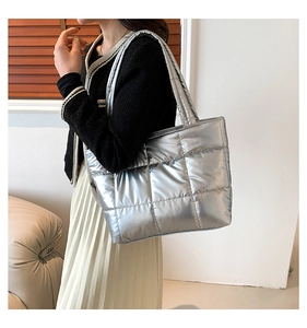 Close-up of stylish metallic silver puffer tote bag with quilted pattern on shoulder