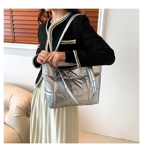 Détail d'un sac cabas matelassé argenté métallisé porté par un mannequin femme