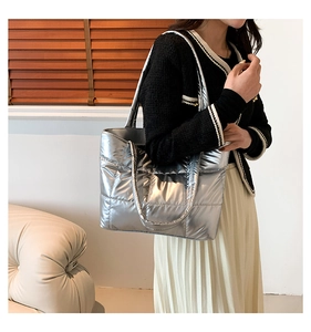 Détail du sac fourre-tout argenté métallisé avec motif matelassé sur modèle