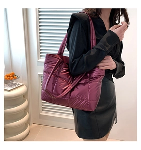 Close-up of quilted burgundy nylon tote bag showing metallic luster and spacious design