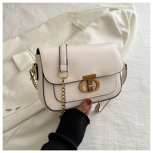 Détail du sac beige avec boucle CD dorée et texture cuir sur tissu texturé