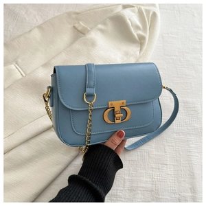 Détail du sac bandoulière en cuir bleu clair avec fermoir doré antique et fini mat
