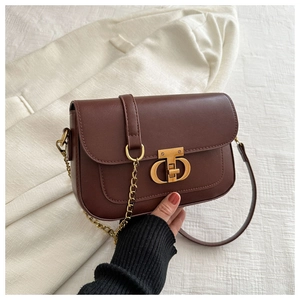 Détail du sac à bandoulière marron vintage avec fermoir doré et bandoulière chaîne