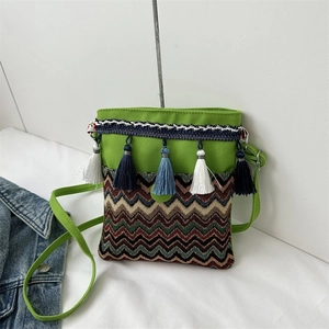 Close-up of ethnic canvas crossbody bag with green top and colorful wave embroidery