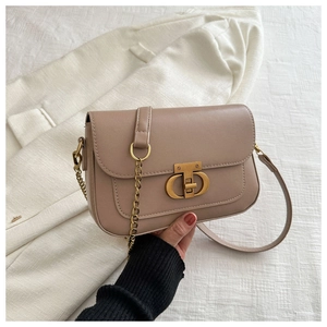 Détail du sac bandoulière en cuir marron clair avec boucle CD dorée et bandoulière chaîne