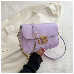 Détail d'un sac bandoulière lavande avec fermoir tournant doré vintage et bandoulière