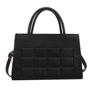 Minimalist black quilted tote bag with golden hardware and adjustable crossbody strap