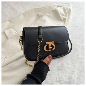 Gros plan du fermoir métallique doré CD sur un sac à bandoulière en cuir noir