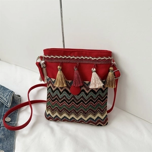 Detailed close-up of ethnic crossbody bag featuring colorful tassels and chevron embroidery