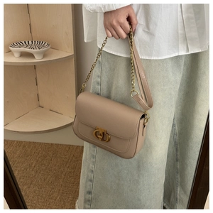 Vue détaillée d'un sac bandoulière en cuir beige avec boucle métallique dorée entrelacée