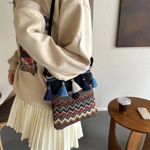Close-up of ethnic crossbody bag with colorful woven patterns and decorative tassels