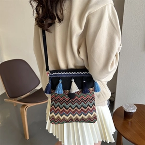 Detail of bohemian canvas crossbody bag featuring colorful tassels and chevron weaving pattern