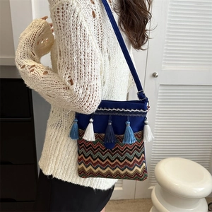 Close-up of ethnic crossbody bag with blue tassels and geometric woven pattern detail