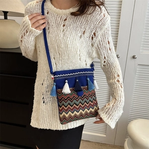 Detail of bohemian blue canvas crossbody bag with wave embroidery and colorful tassels