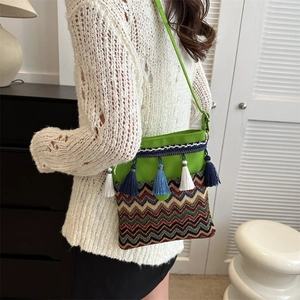 Detail of bohemian cross-body bag featuring colorful fringe and woven canvas patterns