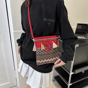 Close-up of Bohemian red crossbody bag with ethnic embroidery and colorful tassel details