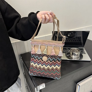 Detail of bohemian embroidery and colorful tassels on an ethnic canvas crossbody bag