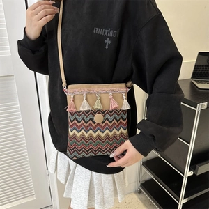 Close-up of bohemian crossbody bag featuring ethnic embroidery and colorful tassels