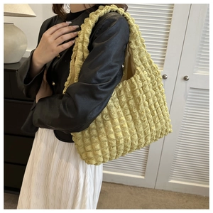 Pale yellow dumpling bag with bubble texture shown in a casual lifestyle setting
