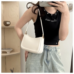 Minimalist white leather underarm shoulder bag with curved design shown on a model