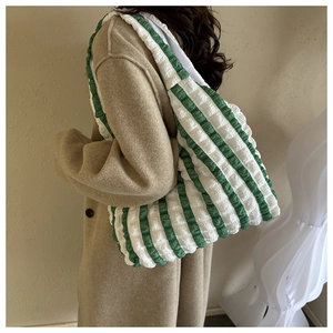 Fashionable green and white striped popcorn bubble tote bag shown on model's shoulder