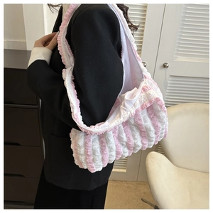 Detail of pink and white striped puffy shoulder bag showing unique bubble pleated texture