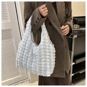 Detail of blue and white striped bubble texture fabric on a large commuter tote bag