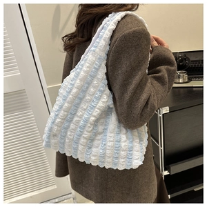 Detailed view of large blue and white striped pleated tote bag with bubble texture