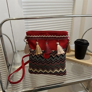 Detail of bohemian ethnic crossbody bag featuring colorful tassels and wave embroidery