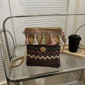 Detailed shot of ethnic crossbody bag with bohemian colorful tassels and woven texture