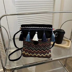 Close-up of Bohemian crossbody bag featuring colorful wavy patterns and five hanging tassels