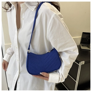 Detail of Klein blue underarm bag with V-shaped quilting and a soft fabric finish