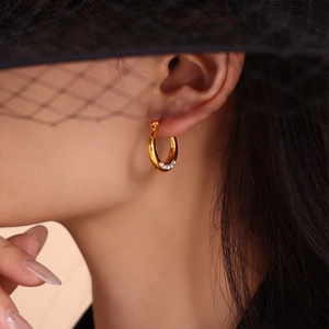 Élégantes créoles en titane plaqué or 18K avec perles blanches sur un mannequin