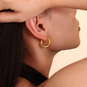 Boucles d'oreilles créoles dorées 18 carats avec cinq perles portées par un mannequin