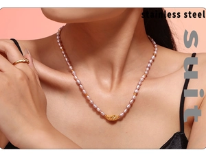 Detail of freshwater pearl choker and vintage brass pendant with an engraved gold ring