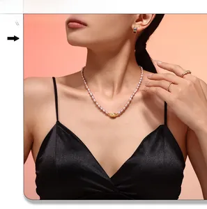 Detail of elegant freshwater pearl necklace with gold hollow pendant on a female model