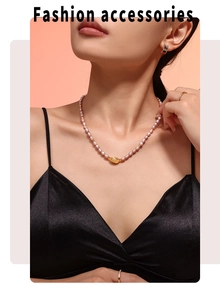 Detail of natural freshwater pearl necklace with gold irregular pendant on a model