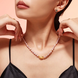 Elegant freshwater pearl necklace with gold textured pendant on a female model