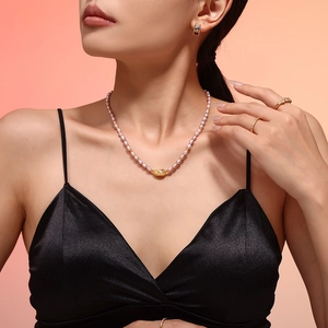 Elegant purple freshwater pearl necklace with gold-tone filigree pendant on model